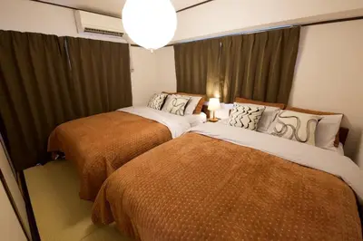 two beds in a small room with curtains at \u30b0\u30ec\u30a4\u30b9\u5411\u5cf6 302 in Tokyo