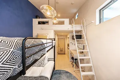 a room with a bunk bed and a ladder at Petit Shinjuku in Tokyo