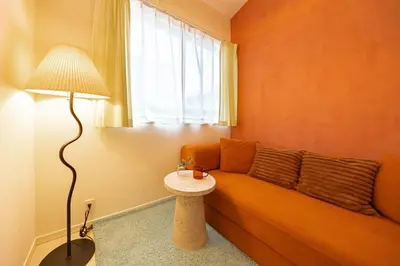 a living room with a couch and a lamp at Petit Shinjuku in Tokyo