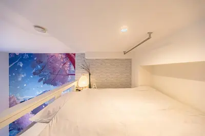 a bedroom with a white bed on a balcony at Petit Shinjuku in Tokyo