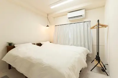 a bedroom with two white beds and a window at T4U Shinjyuku in Tokyo