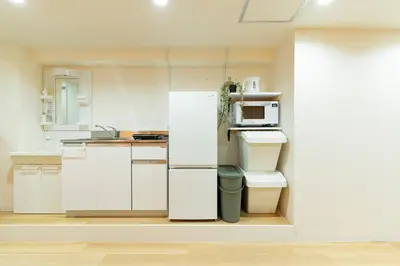 a white kitchen with a refrigerator and a microwave at T4U Shinjyuku in Tokyo