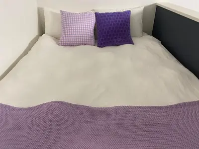 a bed with purple and white sheets and pillows at 201\u53f7 \u5c71\u624b\u7ebf\u8fd1\u4e0a\u91ce\u4e00\u7ad9\u590d\u5f0f\u6e29\u99a8\u65b0\u516c\u5bd3 in Tokyo