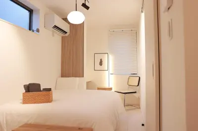 a white bedroom with a bed and a chair at Room #101 - Cozy Stay Higashi Ikebukuro in Tokyo
