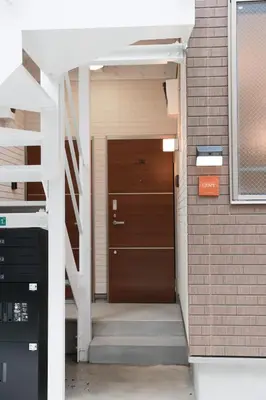 a staircase leading to a door in a building at Room #101 - Cozy Stay Higashi Ikebukuro in Tokyo