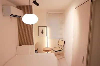 a bedroom with a white bed and a chair at Room #102 - Cozy Stay Higashi Ikebukuro in Tokyo