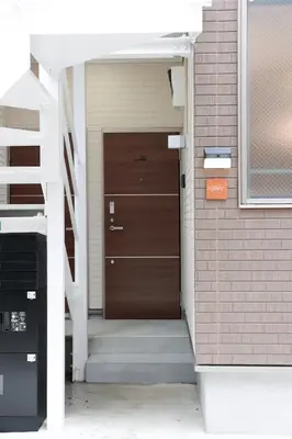 a brown door on a house with stairs at Room #201 - Cozy Stay Higashi Ikebukuro in Tokyo
