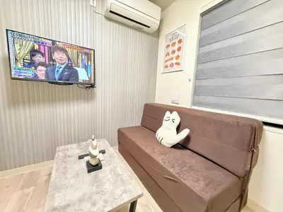 a living room with a brown couch and a table at Shinjuku downtown B2 in Tokyo