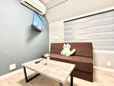 a cat sitting on a couch in a living room at Shinjuku downtown C2 in Tokyo