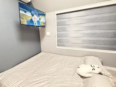 a bedroom with a bed and a flat screen tv at Shinjuku downtown C2 in Tokyo