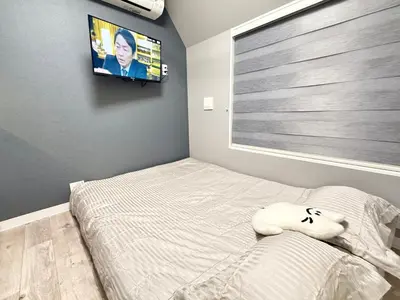 a bedroom with a bed and a flat screen tv at Shinjuku downtown C2 in Tokyo