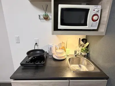 a kitchen counter with a microwave and a sink at Shinjuku downtown C2 in Tokyo
