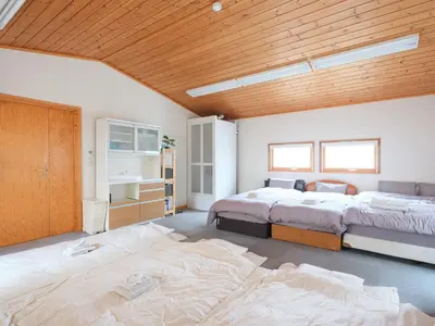 a bedroom with two beds and a wooden ceiling at Urayasu Horie House -\u6d66\u5b89\u5800\u6c5f\u30cf\u30a6\u30b9- Disneyland\u307e\u3067\u7d0430\u5206 Wi-Fi \u99d0\u8eca\u5834\u4ed8\u30671\u68df\u8cb8\u5207 in Tokyo