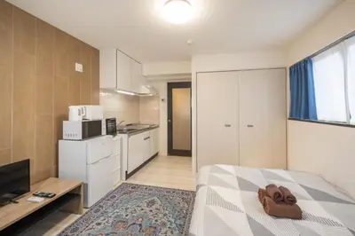 a small room with a bed and a kitchen at BO303 \u30ab\u30c3\u30d7\u30eb\u306b\u6700\u9069 \u6d45\u8349\u5bfa\u305d\u3070 \u65e5\u672c\u4ebaSuperHost in Tokyo