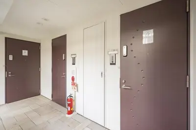 a hallway with brown and white doors and a fire extinguisher at BO303 \u30ab\u30c3\u30d7\u30eb\u306b\u6700\u9069 \u6d45\u8349\u5bfa\u305d\u3070 \u65e5\u672c\u4ebaSuperHost in Tokyo