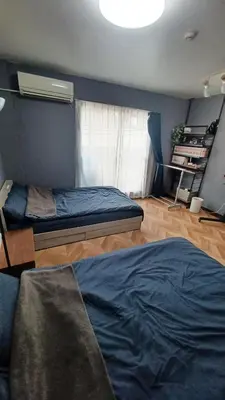 a bedroom with two beds and a window at Y's House Okubo in Tokyo