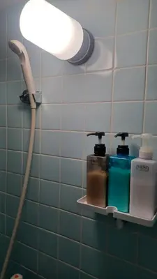 a bathroom with a blow dryer and a light on a wall at Y's House Okubo in Tokyo