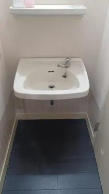 a bathroom with a white sink and a blue tile floor at Y's House Okubo in Tokyo
