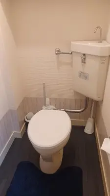 a bathroom with a white toilet and a sink at Y's House Okubo in Tokyo