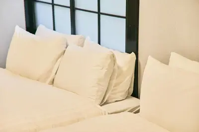 a pile of white pillows sitting on a bed at \u3077\u3075\u304b\u5186\u5fb3\u9418\u30f6\u6df5 in Tokyo