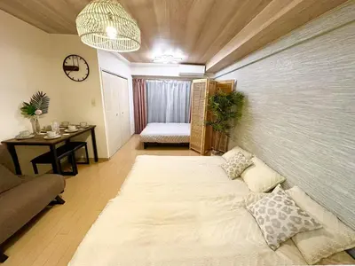 a living room with a large bed and a table at 302\u6d89\u8c37\u533a\u57df \u4e58\u7535\u8f664\u5206\u949f\u5230\u8fbe\u65b0\u5bbf \u5df4\u58eb\u76f4\u8fbe\u6d89\u8c37\u6b65\u884c\u5230\u897f\u65b0\u5bbf\u4e94\u4e01\u76ee8\u5206\u949f max5 in Tokyo