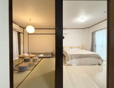 a bedroom with a large bed and a table at AiES\u56db\u3064\u6728 \u56db\u6728\u7ad9\u8d708\u5206\u949f 2\u623f4 \u505c\u8f66\u573a\u514d\u8d39 \u76f4\u8fbe\u673a\u573a\u6674\u7a7a\u5854Asakusa\u94f6\u5ea7 \u8fd1\u5546\u573a\u516c\u56ed \u5927\u7a7a\u7ffc\u6545\u4e61 in Tokyo