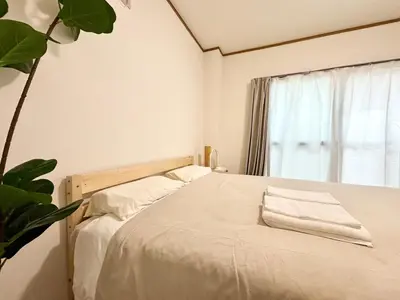a bedroom with a bed with white sheets and a window at AiES\u56db\u3064\u6728 \u56db\u6728\u7ad9\u8d708\u5206\u949f 2\u623f4 \u505c\u8f66\u573a\u514d\u8d39 \u76f4\u8fbe\u673a\u573a\u6674\u7a7a\u5854Asakusa\u94f6\u5ea7 \u8fd1\u5546\u573a\u516c\u56ed \u5927\u7a7a\u7ffc\u6545\u4e61 in Tokyo