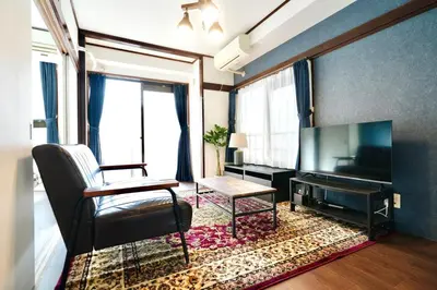 a living room with a chair and a flat screen tv at AM's 501 5 min to Ikebukuro 13 min to Shinjuku Station 19 min to Shibuya Station in Tokyo