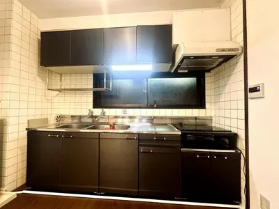a kitchen with black cabinets and a sink at AM's 501 5 min to Ikebukuro 13 min to Shinjuku Station 19 min to Shibuya Station in Tokyo