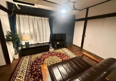 a living room with a leather couch and a rug at AM's 501 5 min to Ikebukuro 13 min to Shinjuku Station 19 min to Shibuya Station in Tokyo