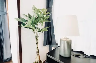 a table with a lamp and a vase with a plant at AM's 501 5 min to Ikebukuro 13 min to Shinjuku Station 19 min to Shibuya Station in Tokyo