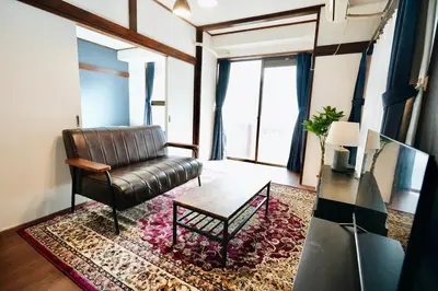 a living room with a leather chair and a coffee table at AM's 501 5 min to Ikebukuro 13 min to Shinjuku Station 19 min to Shibuya Station in Tokyo