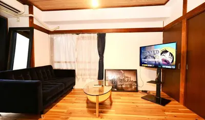 a living room with a black couch and a tv at AM's 701 Ikebukuro 5 min Shinjuku Station 13 min Shibuya Station 19 min in Tokyo