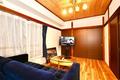 a living room with a blue couch and a table at AM's 701 Ikebukuro 5 min Shinjuku Station 13 min Shibuya Station 19 min in Tokyo