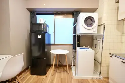 a kitchen with a refrigerator and a table and a microwave at AM's 701 Ikebukuro 5 min Shinjuku Station 13 min Shibuya Station 19 min in Tokyo