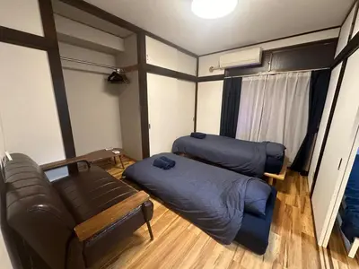 a living room with two beds and a couch at AM's 502 Movie 5 min to Ikebukuro 13 min to Shinjuku Station 19 min to Shibuya Station with coworking space in Tokyo