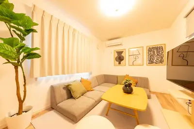 a living room with a couch and a table at Birthday House Komagome in Tokyo