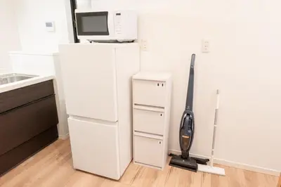 a white refrigerator with a microwave on top of it at Birthday House Komagome in Tokyo