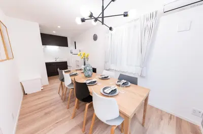a dining room with a wooden table and chairs at Birthday House Komagome in Tokyo
