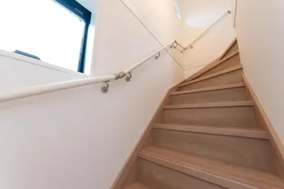 a staircase in a house with wooden floors and a window at Birthday House Komagome in Tokyo