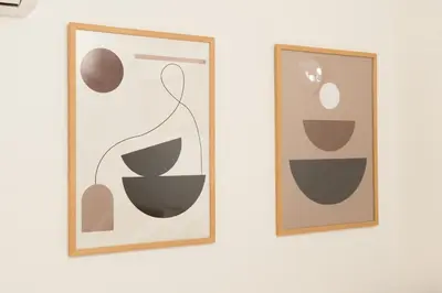 two framed artworks on a white wall at Birthday House Komagome in Tokyo