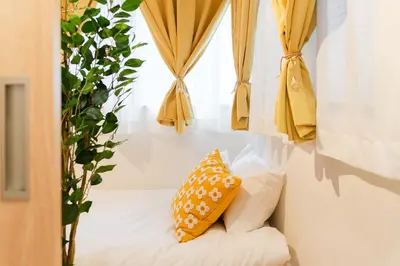 a bed with a yellow pillow and a window at 70sqm Private House, Major Tokyo Spots & Free Parking in Tokyo