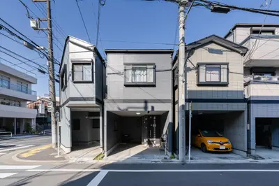 a yellow car parked in a garage next to a house at 70sqm Private House, Major Tokyo Spots & Free Parking in Tokyo