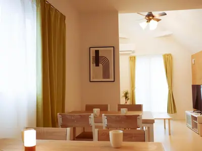a dining room with a table and chairs and a ceiling fan at MSTAY\u9ad8\u7530\u99ac\u5834one in Tokyo
