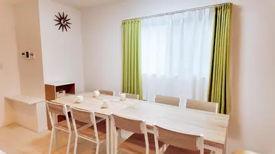 a dining room table with chairs and a large window at MSTAY\u9ad8\u7530\u99ac\u5834one in Tokyo