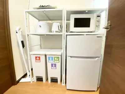 a kitchen with a refrigerator and a microwave at OHANAJAYAsquare302 in Tokyo