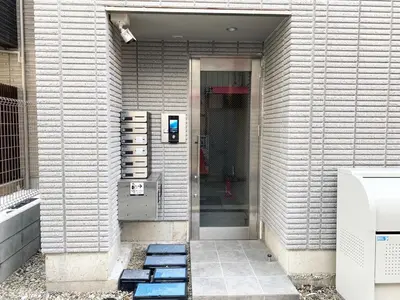 a walkway leading to a building with a pay phone at OHANAJAYAsquare302 in Tokyo