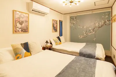 a bedroom with two beds and a painting on the wall at 2min from ShinKoiwaSta 13min TokyoSta 14guests 4BR in Tokyo