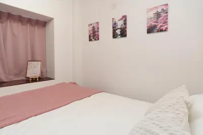 a bedroom with a bed and four pictures on the wall at 2min from ShinKoiwaSta 13min TokyoSta 14guests 4BR in Tokyo