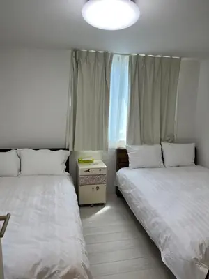a bedroom with two beds and a window at Tokyo Link House Halona-Direct to Shinjuku, Shibuya, Ginza in Tokyo